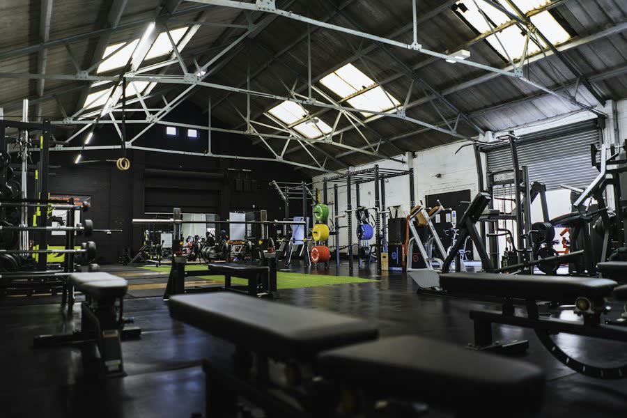 Fitnessstudio in einer Industriehalle mit Hantelbänken.