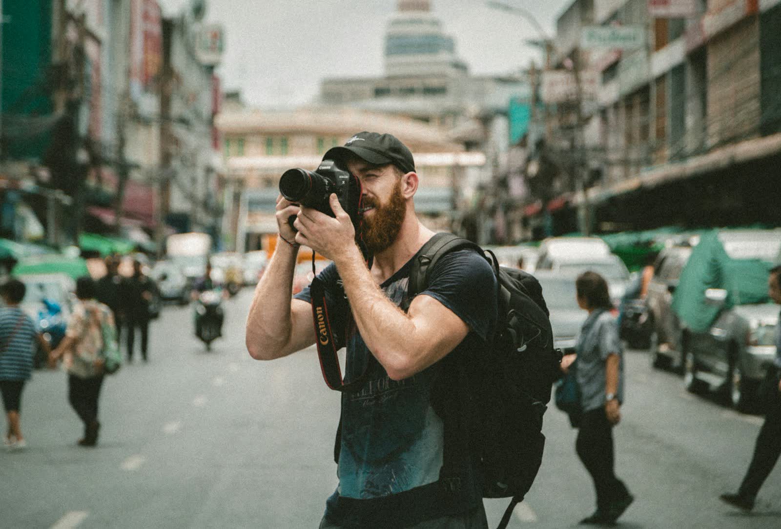 Fotograf mit Kamera auf einer belebten Straße